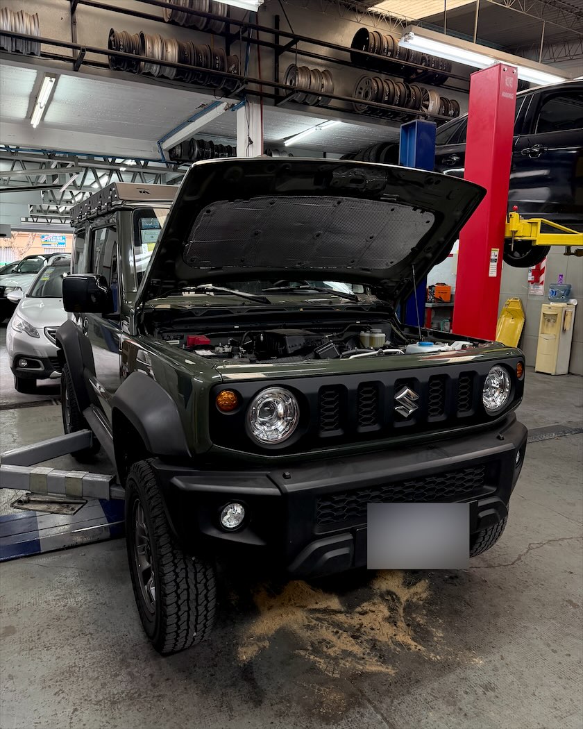 Suzuki Jimny con el capó abierto en el taller