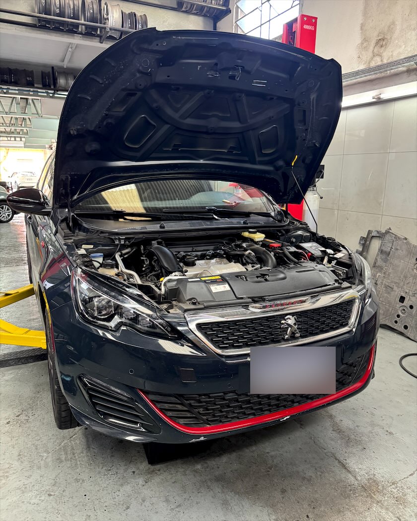 Peugeot 308 con el capó abierto, listo para revisar el motor